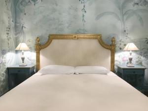 维罗纳Casa Borsari Suite的一间卧室配有一张大床,桌子上放着两盏灯