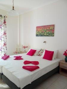 帕罗奇亚梅莱蒂斯公寓酒店的一间卧室配有一张带红色枕头的床