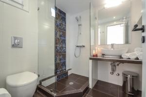 纳克索乔拉Sun Beach Hotel的一间带卫生间、水槽和镜子的浴室