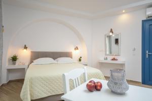 纳克索乔拉Sun Beach Hotel的一间卧室配有一张床和一张桌子,上面有苹果