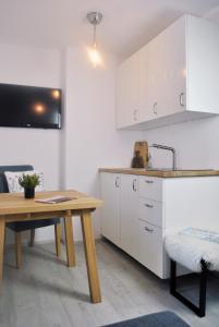 克拉尼斯卡戈拉Apartment Loyd, Kranjska Gora - studio的厨房配有白色橱柜、桌子和水槽。