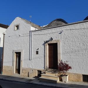阿尔贝罗贝洛Alberobello Casa Vacanze - Pathos tra i Trulli的白色砖砌的建筑,设有门和楼梯