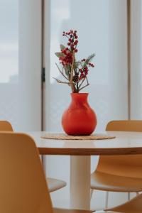 埃尔切Apartamento de Esther y Javi的红色花瓶,花朵坐在桌子上