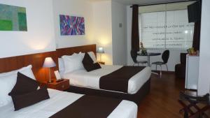 马尼萨莱斯加尔韦斯酒店的酒店客房设有两张床和一张桌子。