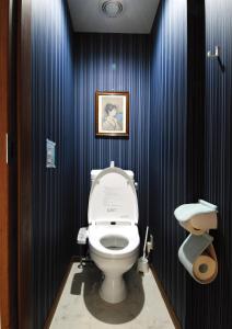 东京花庵旅舍的一间带卫生间的浴室和墙上的照片