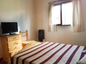 埃博森Alojamiento Las Retamas的一间卧室配有一张床、一台电视和一个窗口