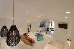 斯泰里达Naxos Cave Suites的带沙发和电视的白色客厅