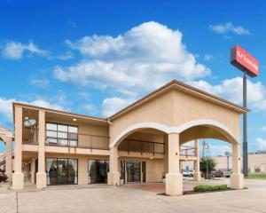 希尔斯伯勒Econo Lodge Hillsboro I-35的一座建筑前面的商店,上面有古柯标志