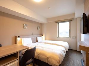 甲府Comfort Inn Kofu的酒店客房配有一张床、一张书桌和一张书桌。