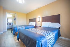欧文欧文十字口酒店及套房的酒店客房,配有两张带蓝色床单的床