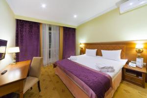 喀山比利亚尔宫酒店的酒店客房设有一张大床、一张书桌和一张书桌。