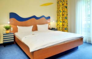 舍纳贝克浴疗公园酒店的一间卧室配有一张大床和木制床头板