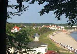 宾茨Hotel Pension Haus Colmsee的享有海滩美景,设有一组停车位