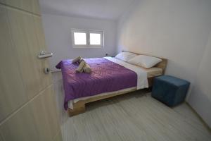 盖夫盖利亚Luna Apartments Gevgelija的一间小卧室,配有紫色的床和窗户
