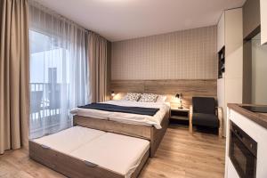 斯塔利斯莫克维克Trio Tatry的一间卧室设有两张床、一把椅子和一个窗户。