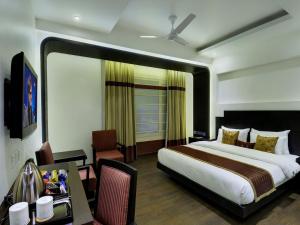 新德里Hotel Godwin Deluxe -Near New Delhi Railway Station - Paharganj的一间卧室配有一张大床和一张桌子
