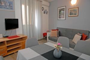 科米扎Apartment Tina的客厅配有沙发和带电视的桌子