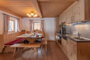 蒂罗尔-基希贝格Berggasthof Staudachstub'n的厨房配有木制橱柜和木桌。