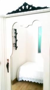 TroiaAlloggio Cattedrale的卧室配有一张带镜子的白色床