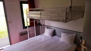 保拉扎克普瑞米尔佩里杰布拉扎克经典酒店的宿舍间的一张床位,配有一张双层床和一扇窗户