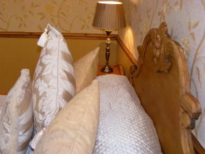 LangsettThe Dog and Partridge的一间卧室配有带枕头和台灯的床