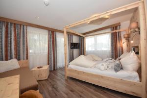 瑙德斯Gasthof Martha的卧室配有带白色枕头的木制天蓬床