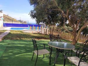 卡拉德莫尔Villa La Canarita的一个带游泳池的庭院里的桌椅