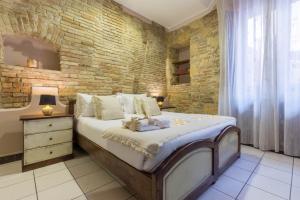 卡利亚里阿勒库巴雷诺旅馆的一间卧室设有一张大床和砖墙