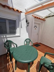克鲁兹·德·特赫达Casa rural Juan y Juana Canino的配有电视的客房内的绿色桌椅