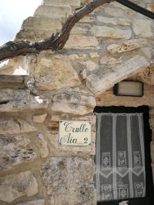 Villa Castelli马塞里亚希亚尼皮考拉旅馆的建筑上带有标志的石墙