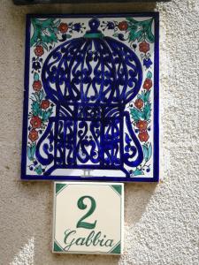Villa Castelli马塞里亚希亚尼皮考拉旅馆的墙上挂着鸟笼的蓝色标志