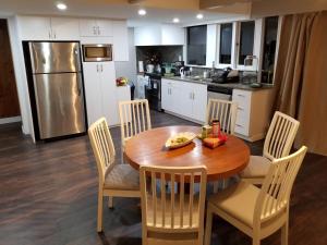 北温哥华City Gardens Suites B&B的带木桌和椅子的厨房以及带冰箱的厨房。