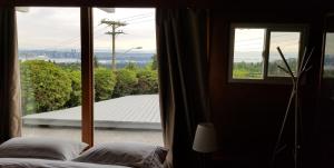 北温哥华City Gardens Suites B&B的卧室设有窗户,享有屋顶的景色