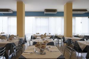 切塞纳蒂科Hotel Rondinella的用餐室设有桌椅和窗户。