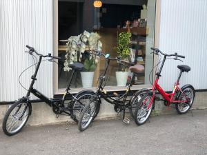 札幌Guesthouse OYADO SAPPORO的两辆自行车停在商店窗户前