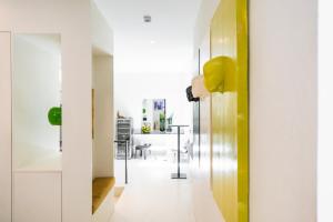 贝加莫乐芙尼酒店的一间设有白色墙壁和黄色装饰的走廊的客房