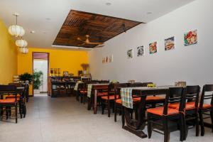 会安La An Central Boutique Villa的用餐室设有桌椅和黄色的墙壁