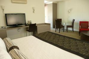 米塔贡Springs Mittagong的酒店客房设有床、电视和桌子。