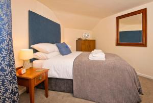 马特洛克Cottage Retreat near Peak District and Chatsworth House的一间卧室配有一张床和一张带台灯的桌子