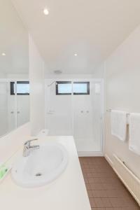坎贝尔港南洋度假别墅的白色的浴室设有水槽和淋浴。