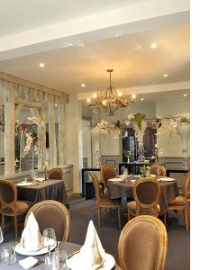 伊苏丹Logis Hôtels Restaurant Les 3 Rois的一间带桌椅和吊灯的用餐室