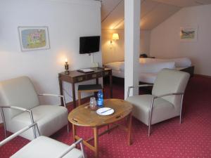 Alt Sankt JohannLandhaus an der Thur的酒店客房带两张床和一张桌子以及椅子。