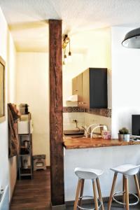 蒙彼利埃La Fontaine - Studio Ecusson的厨房配有2张凳子和带水槽的台面