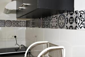 蒙彼利埃La Fontaine - Studio Ecusson的厨房设有长凳和黑白墙