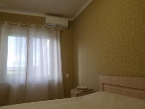 第比利斯marini的一间卧室配有床和带窗帘的窗户