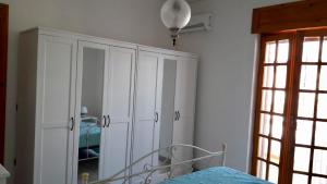 莱波拉诺Villa Peppino的一间卧室配有床和白色橱柜