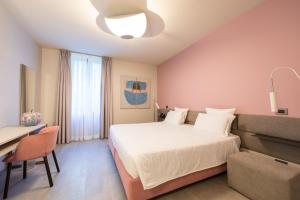 贝加莫乐芙尼酒店的一间卧室配有一张床、一张桌子和一把椅子