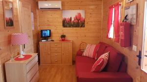 波尔莱扎Chalet Lake Lugano, Vienna 18的客厅配有红色沙发和书桌