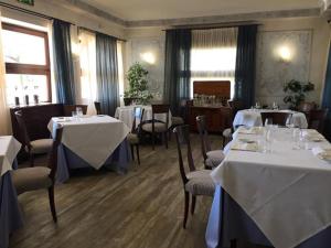 西尔米奥奈路加那帕可阿拉戈酒店的餐厅配有桌椅和白色的桌布