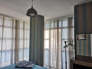 高尼奥Vacation home in Gonio的一间卧室设有窗户、一张床和一个吊灯。
